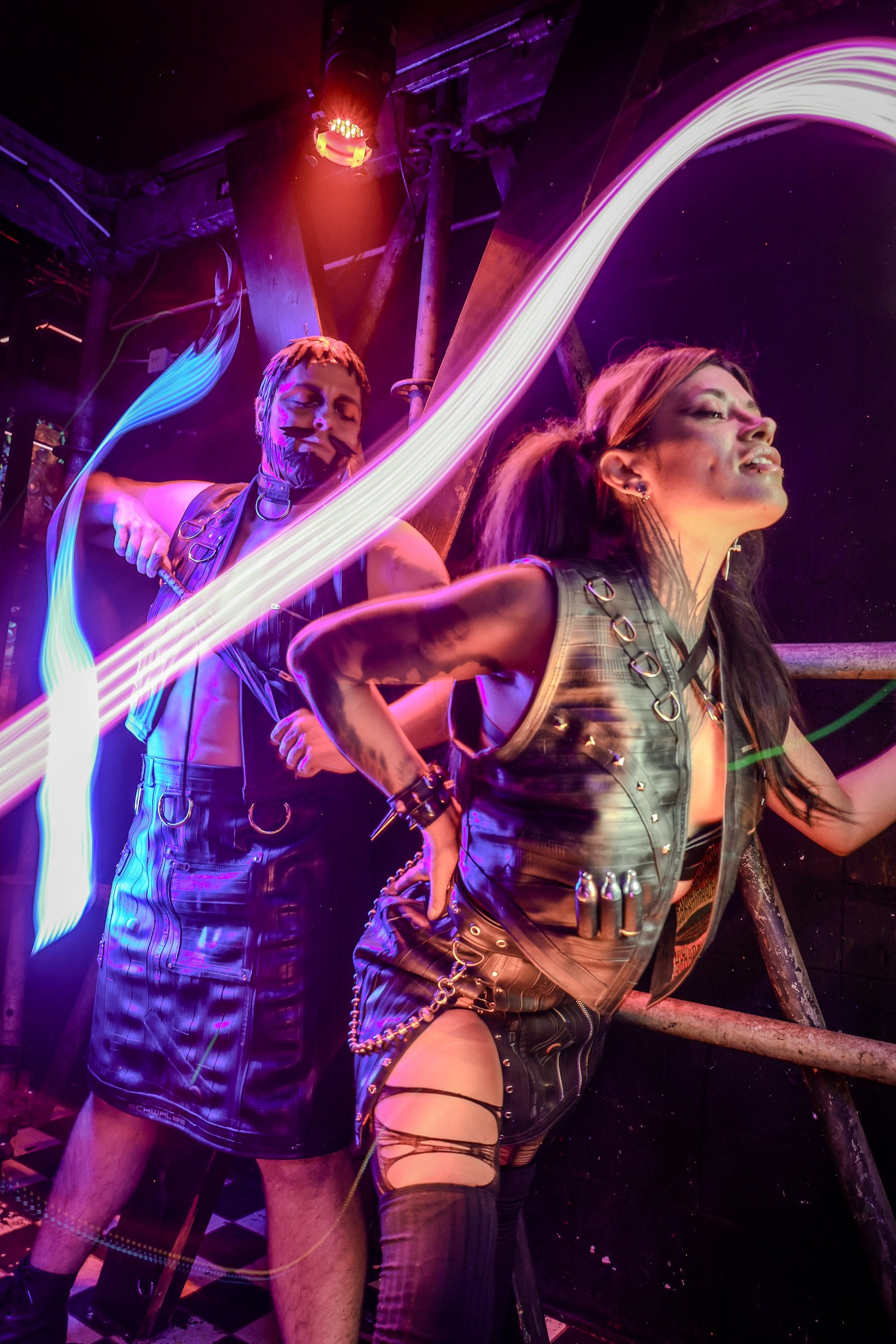 Model wearing upcycled inner tube harness and vest, lit with neon streaks